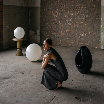 Pantheone I designer speaker next to a model and other objects