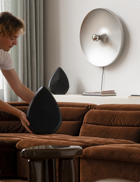 user styling Pantheone Obsidian black speaker in luxury living room with curved brown sofa