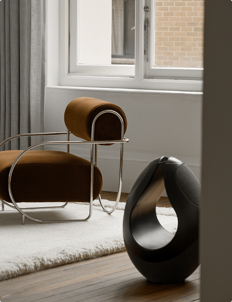 Pantheone I sculptural speaker styled in sunlit interior with Bauhaus-inspired lounge chair and soft rug
