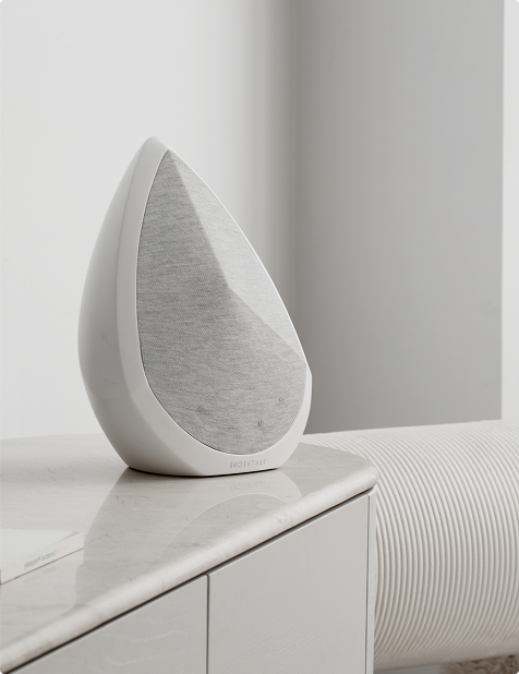 obsidian white wireless speaker in a bright light on a bedside cabinet