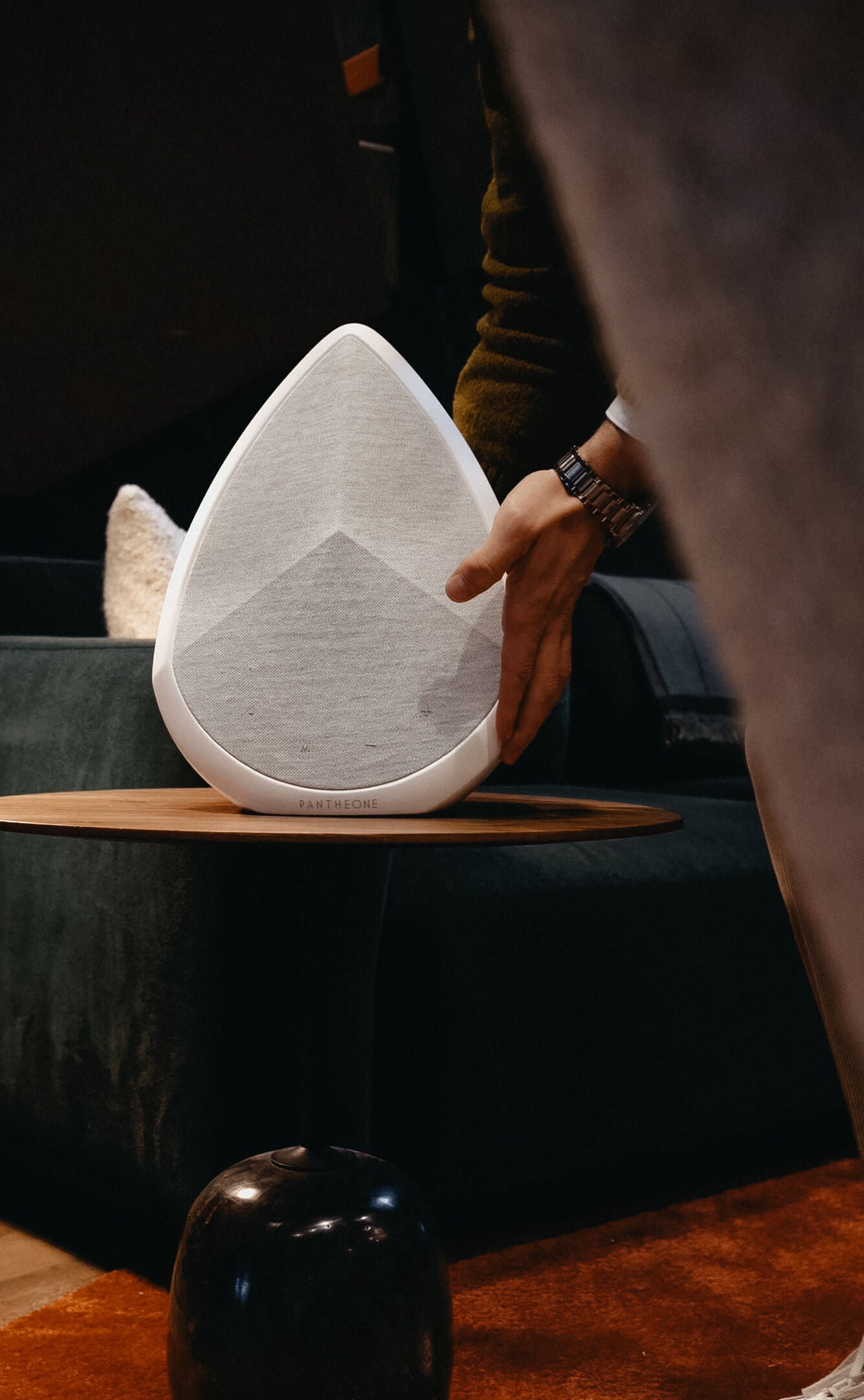 user placing the Pantheon Obsidian portable wireless speaker on a side table