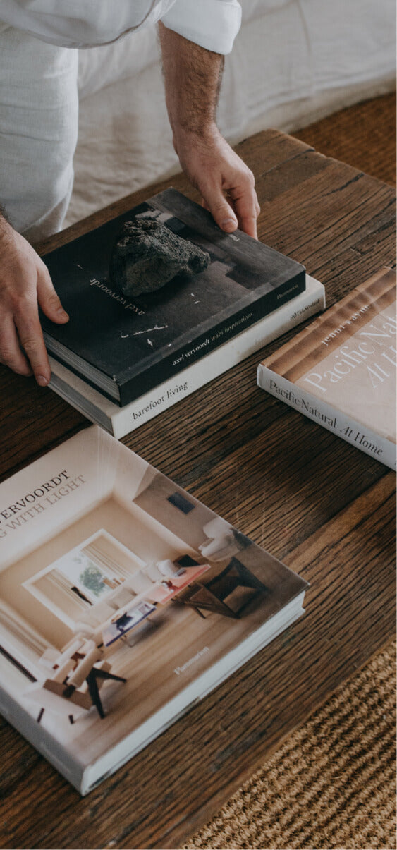 A man organising books on a wooden table