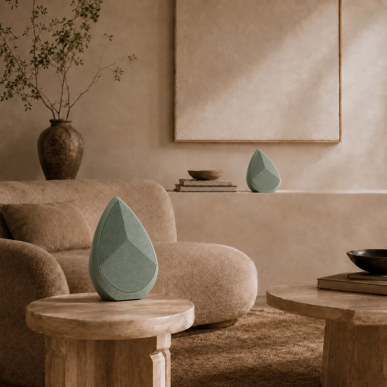 Two Sage Obsidian speakers and decorative items on wooden tables in a living room setting.