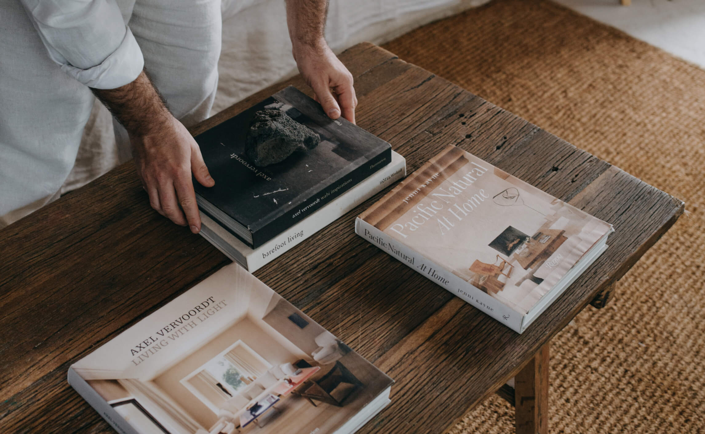 A man organising books on a wooden table