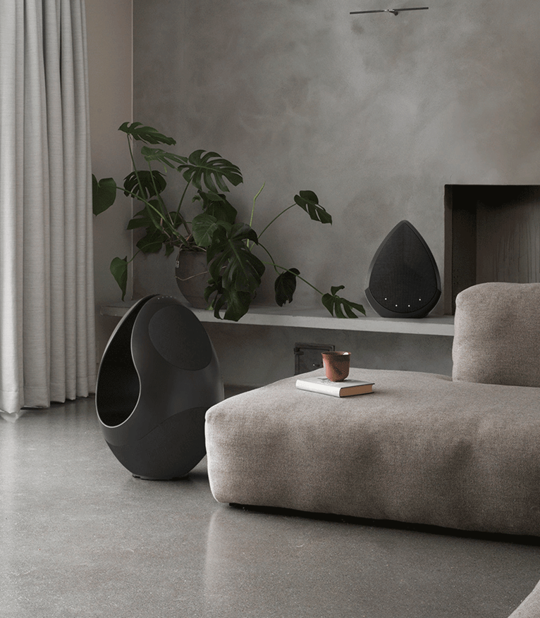 Pantheone I sculptural floor speaker paired with Obsidian compact wireless speaker on cabinet in modern living space