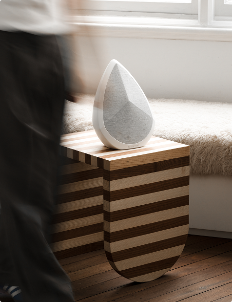 Obsidian speaker placed on a sidetable in a bedroom with natural light