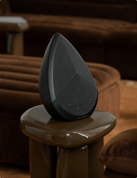 Pantheone Obsidian portable bluetooth speaker on a side table in a modern living room