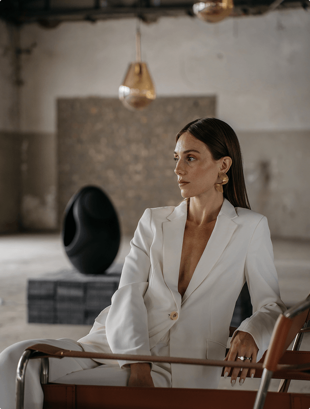 A model sits and listening to the Pantheone I speaker playing 