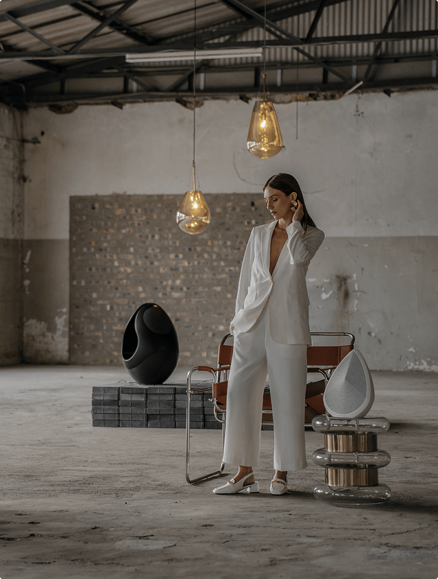 A model surrounded with Pantheone wireless speakers in an industrial room