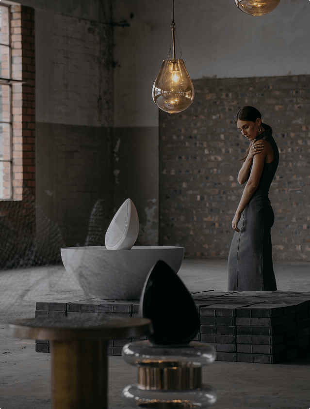 A model standing and looking at the Obsidian wireless speakers