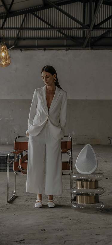A woman standing next to the Obsidian wireless speaker