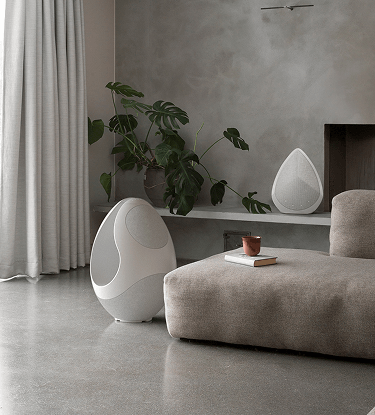 Pantheone I and Obsidian designer speakers in a modern living room with bright light 