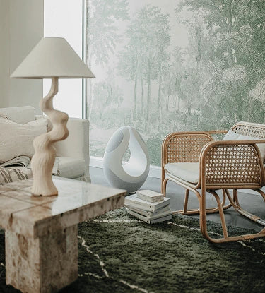 White Pantheone I high-end wireless speaker in modern luxury interior beside tufted ottoman and soft lounge seating