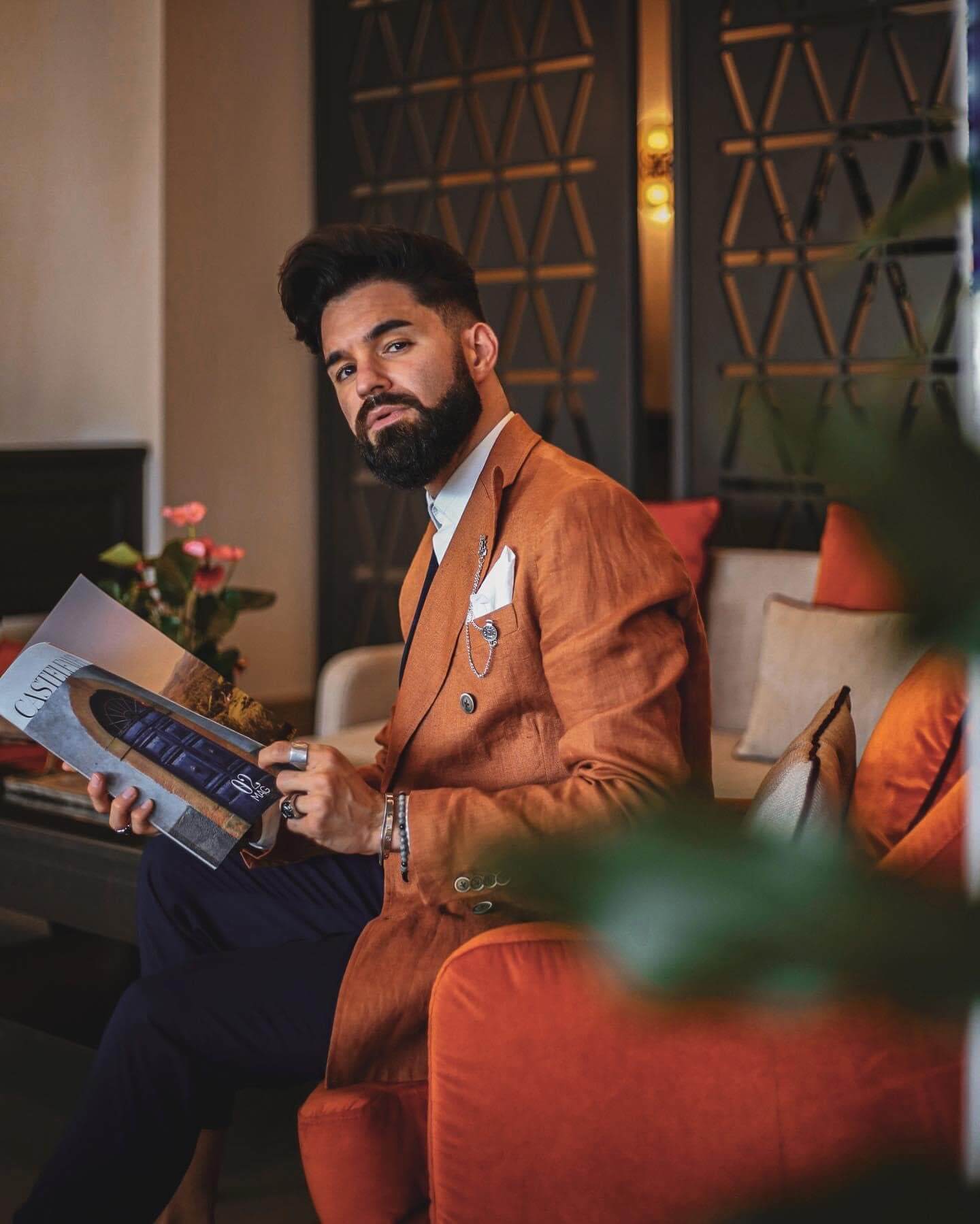 a stylish man reading a magazine in the hotel lobby