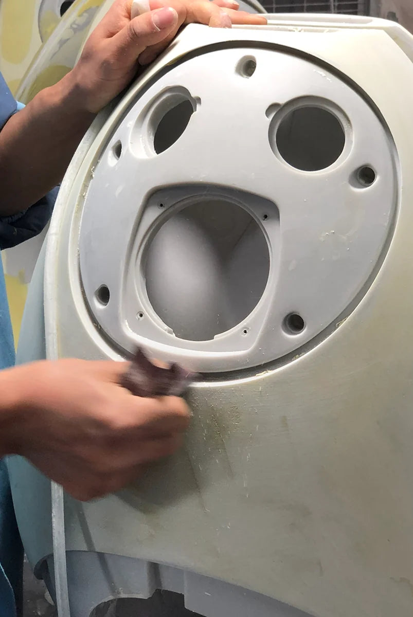 Maker refining the driver openings of a Pantheone resin speaker enclosure by hand