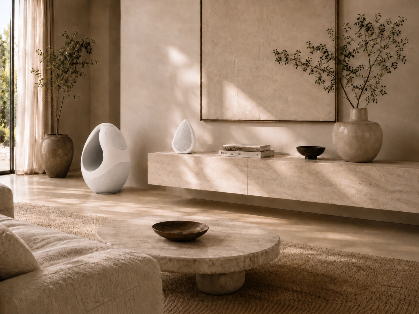 Modern living room with neutral tones, furniture, and the Pantheone I and Obsidian speakers serve as a decorative elements.
